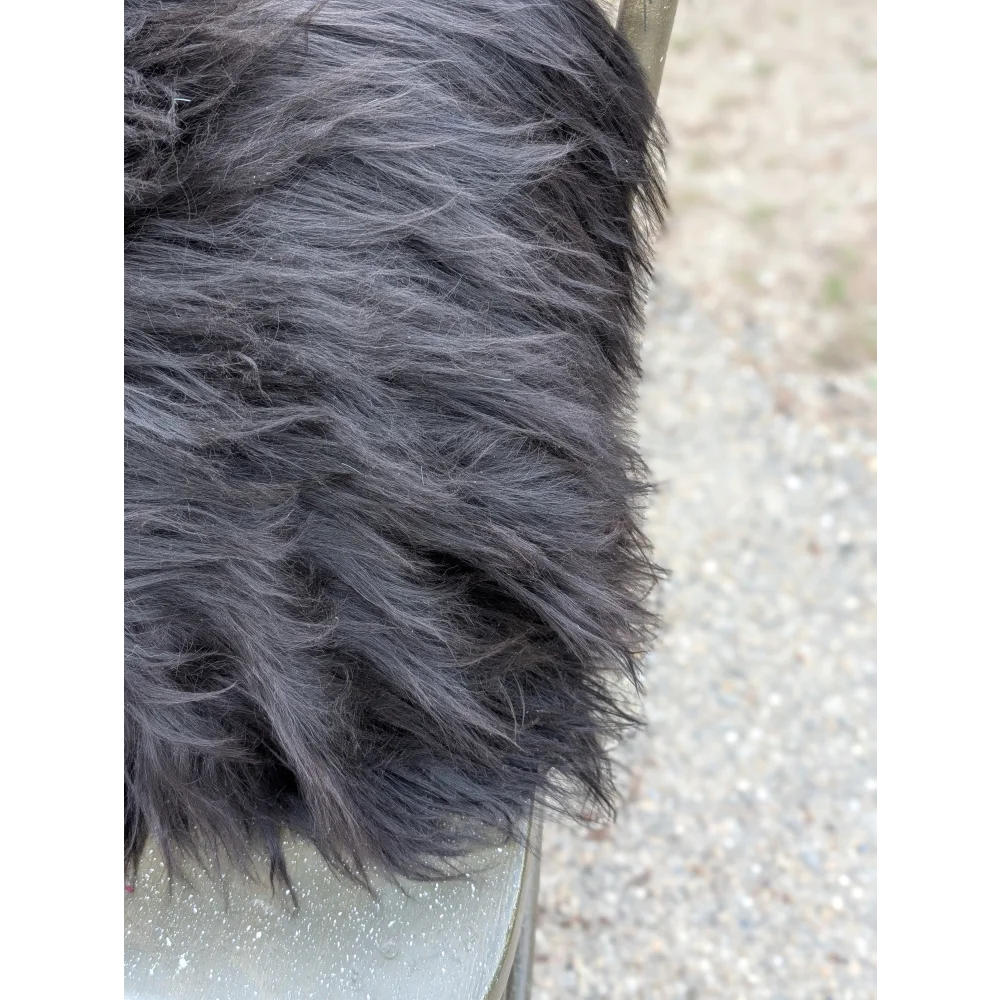 A thick dark gray faux fur blanket with soft plush texture inspired by natural cowhide and long wool design