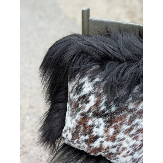Speckled cowhide pillow with natural cowhide spots and fluffy black long wool faux fur trim perfect for cozy decor