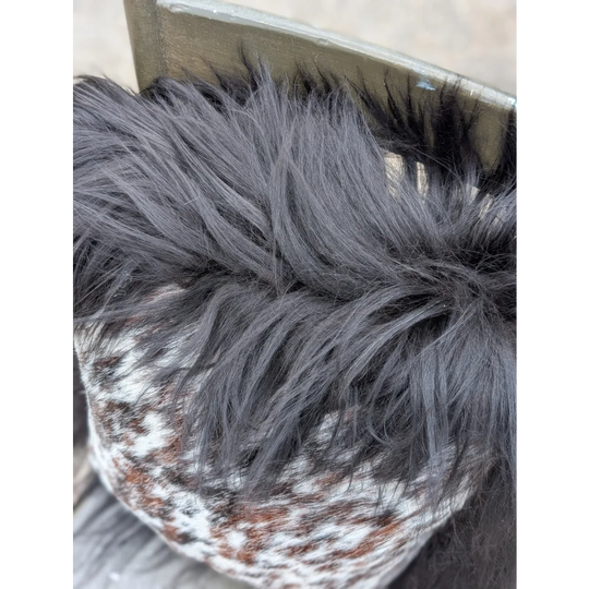 A cozy knit pillow with natural cowhide pattern and dark gray long wool faux fur trim perfect for sewing machines use