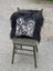 Black and white natural cowhide pillow with speckled pattern and thick long wool black Icelandic fur trim