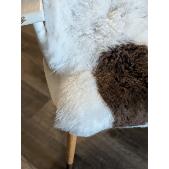 A cozy plush medium spotted icelandic sheepskin throw with soft white and rich brown short wool patchwork design