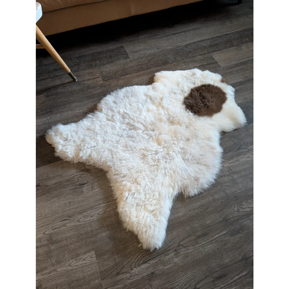 White icelandic sheepskin rug with a brown patch featuring short wool perfect for cozy home decor