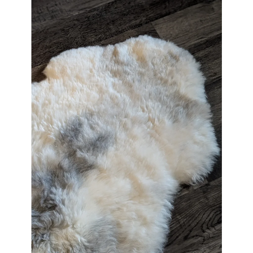 A soft fluffy icelandic sheepskin rug with natural white base and gray patches made of short wool, spot14 model