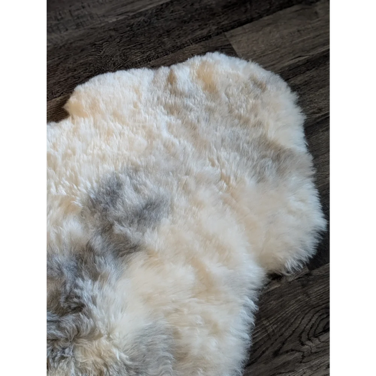A soft fluffy icelandic sheepskin rug with natural white base and gray patches made of short wool, spot14 model