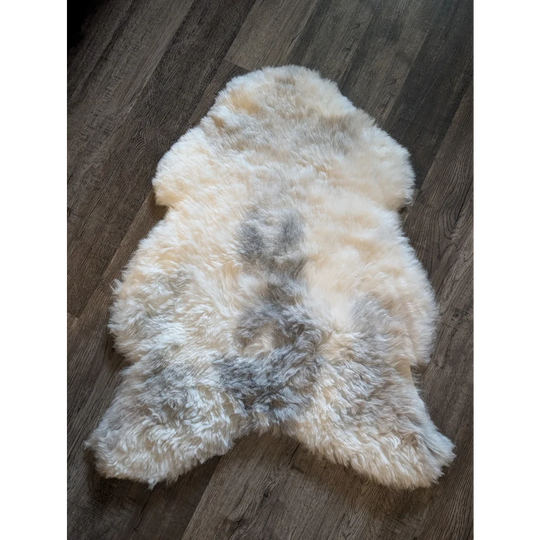 A soft icelandic sheepskin rug with natural cream and gray short wool in medium spotted pattern 40.5 x 29.5 inches