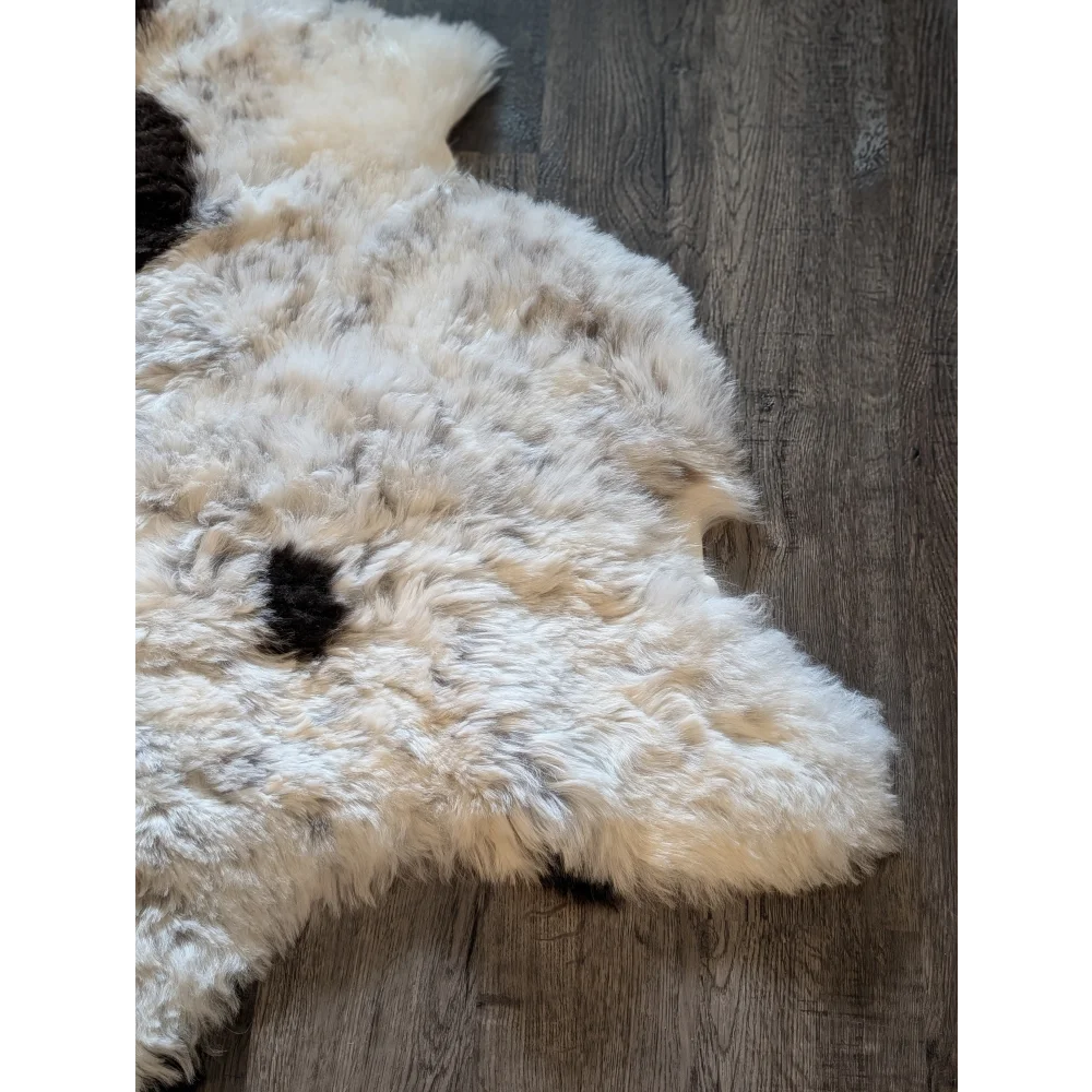 Fluffy white icelandic sheepskin rug with black speckles natural edges medium spotted short wool 41.5 x 30.5 inches