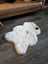 White icelandic sheepskin rug with natural black spots made of soft short wool measuring 41 by 32 inches