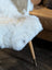 White fluffy spotted icelandic sheepskin chair cover with short wool and subtle beige patches soft natural texture
