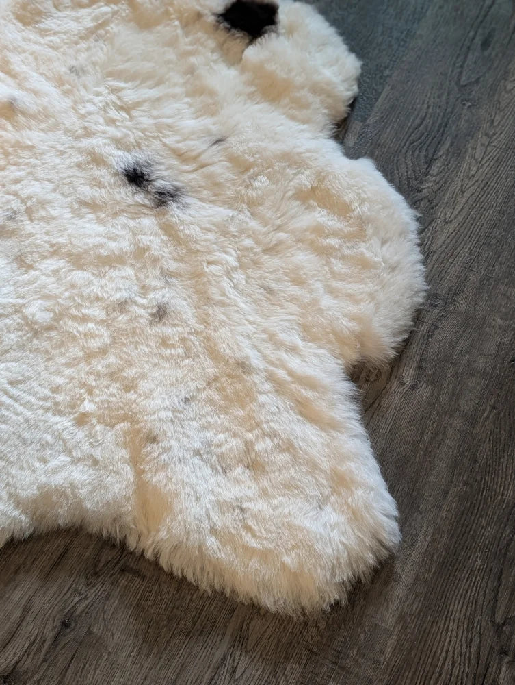 Cream-colored icelandic sheepskin rug with natural black markings medium spotted short wool 41 by 32 inches