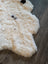 Cream-colored icelandic sheepskin rug with natural black markings medium spotted short wool 41 by 32 inches