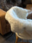 White fluffy icelandic sheepskin short wool throw draped over white high chair for cozy seating