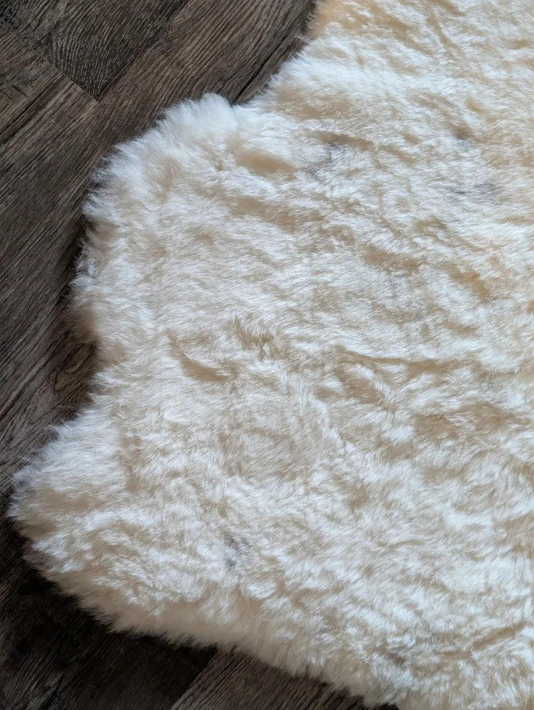 Cream-colored plush icelandic sheepskin rug with soft short wool and natural irregular edges 40.5 x 32 inches