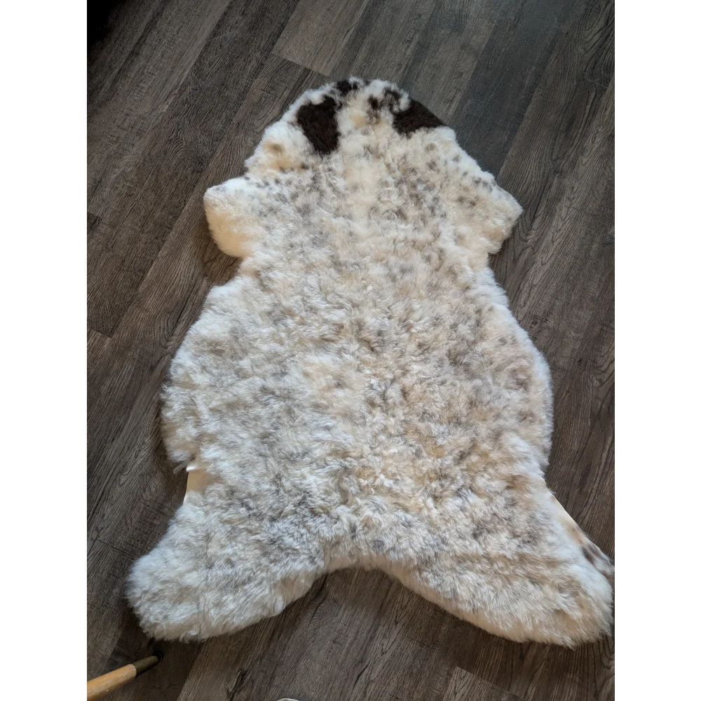 A fluffy icelandic sheepskin rug with creamy white base and dark brown patches made of short wool spot 19 large size