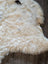 Cream-colored curly icelandic sheepskin rug with soft short wool and natural edges 42 x 32 medium spot