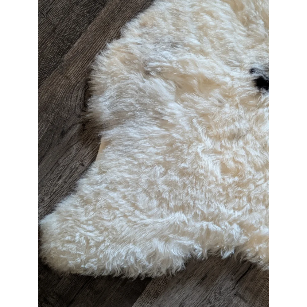 Cream-colored curly icelandic sheepskin rug with soft short wool texture and natural irregular edges spot2 medium size