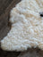 Cream-colored curly icelandic sheepskin rug with soft short wool texture and natural irregular edges spot2 medium size