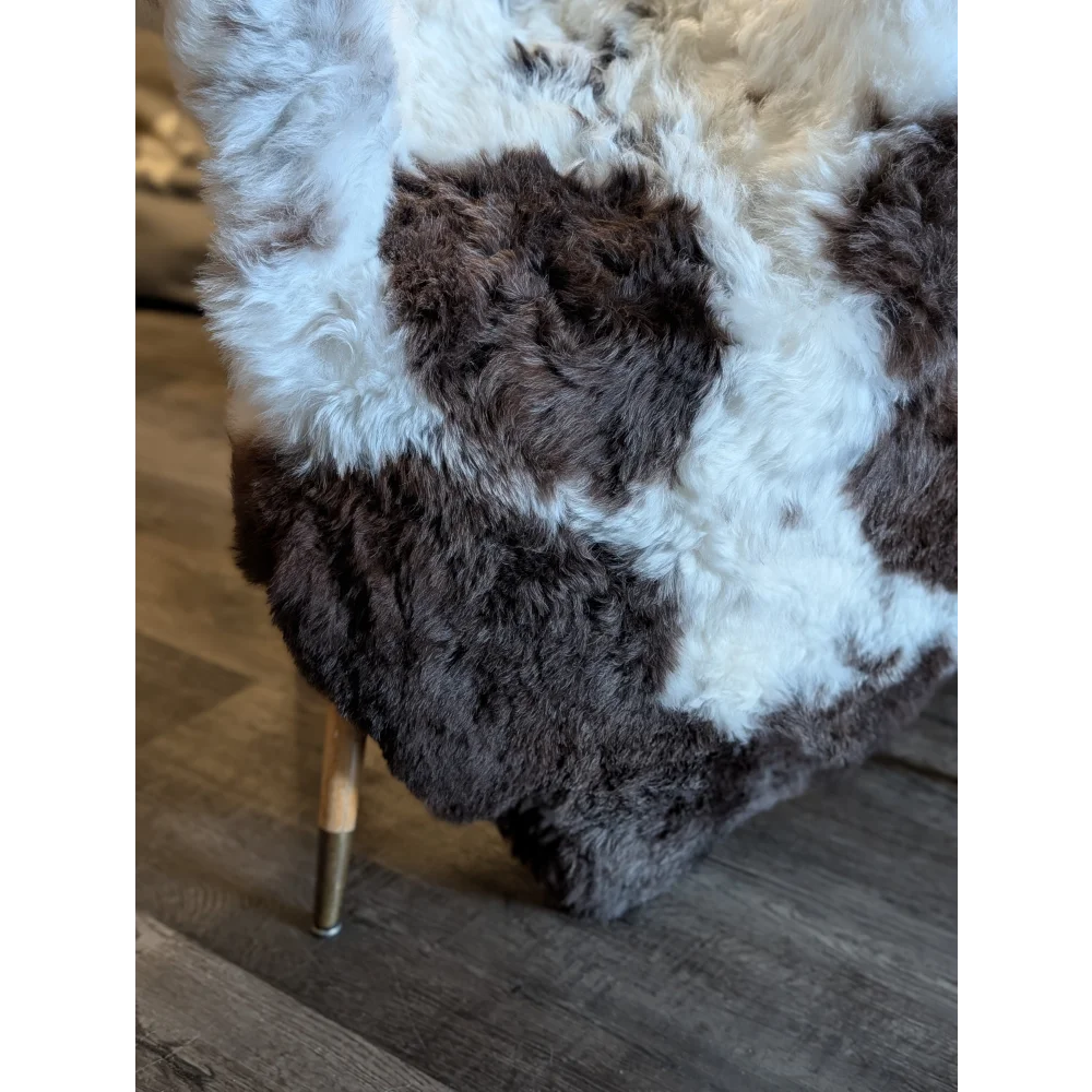 A plush large icelandic sheepskin throw with natural white and dark brown short wool patchwork fur pattern