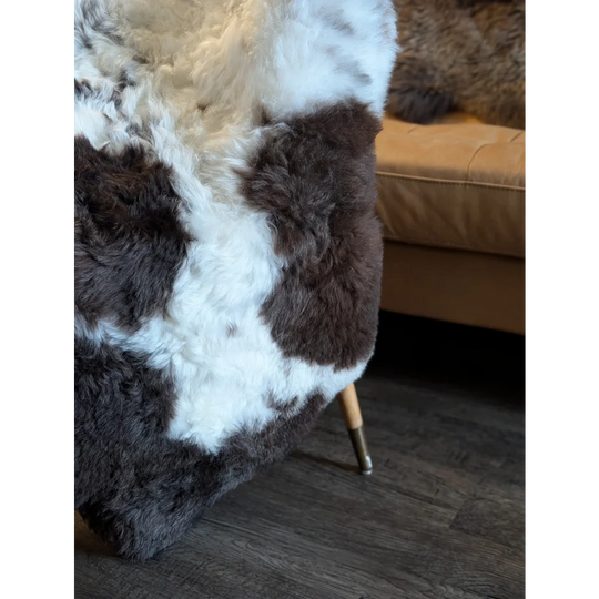 A plush large spotted icelandic sheepskin rug with soft white and dark brown short wool fur texture