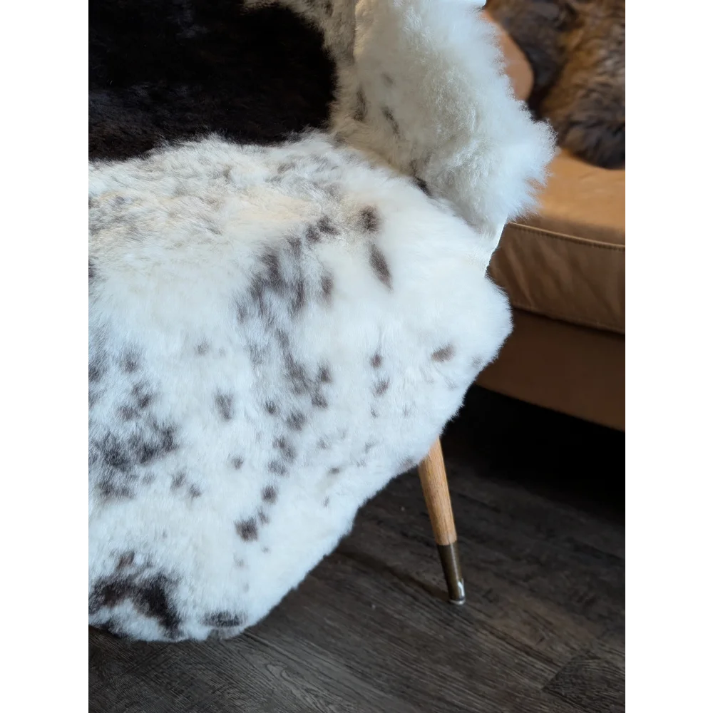 White and black spotted faux fur chair cover with plush texture made from short wool icelandic sheepskin 48 by 34 inches