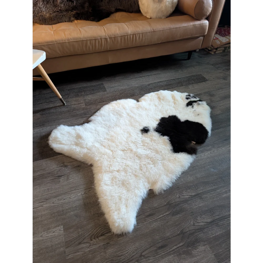 White and black spotted icelandic sheepskin rug with short wool fluffy texture shaped like a bear 49 x 32 inches