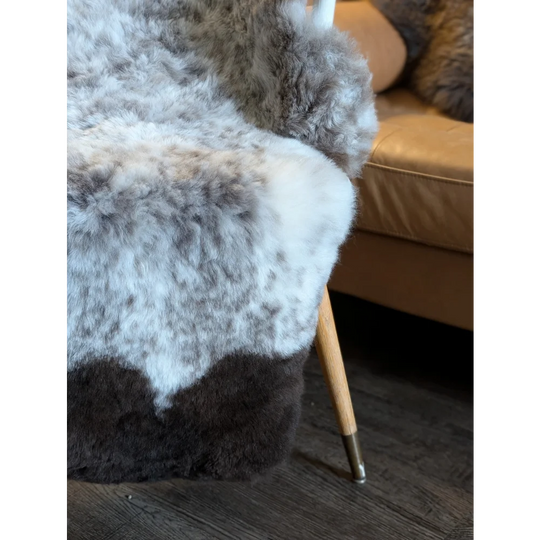 A large 49 by 31 icelandic sheepskin throw with short wool in white gray and dark brown mottled pattern