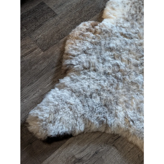 A large 49 x 31 icelandic sheepskin rug with short wool in mottled gray and cream natural colors