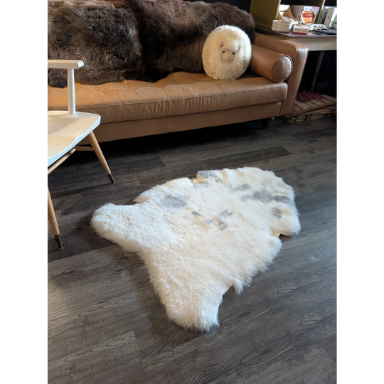 White spotted icelandic sheepskin rug with short wool texture and natural irregular edges for cozy decor