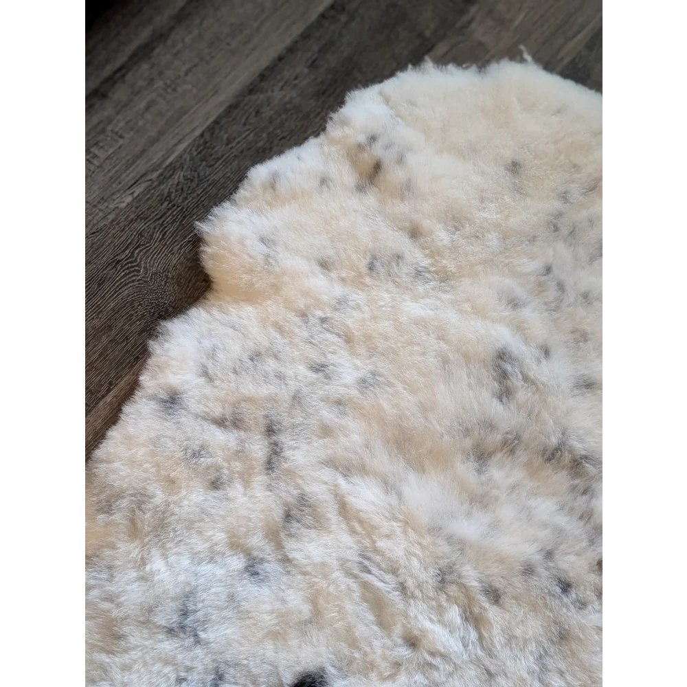 Cream icelandic sheepskin rug with soft short wool and dark gray speckles perfect for cozy decor