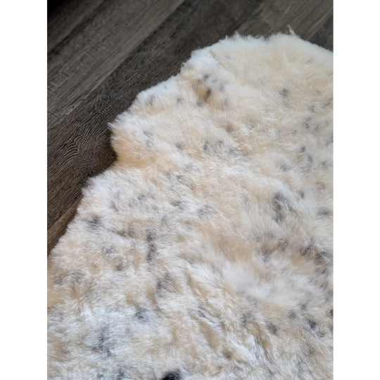 Cream icelandic sheepskin rug with soft short wool and dark gray speckles perfect for cozy decor