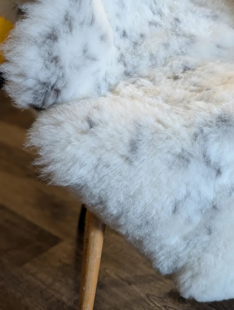 White and gray speckled icelandic sheepskin throw blanket with soft short wool texture 45 by 31 inches large spot38