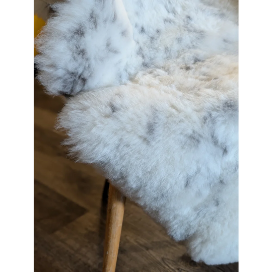 White and gray speckled icelandic sheepskin throw blanket with soft short wool texture 45 by 31 inches large spot38