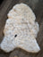 Cream-colored icelandic sheepskin rug with soft short wool and dark speckles in large 45 by 31 size