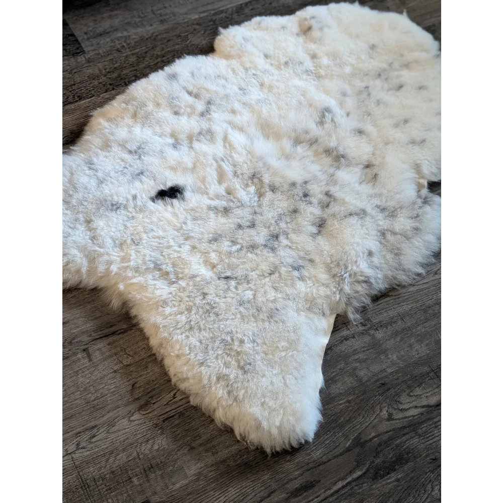 A plush off-white icelandic sheepskin rug with soft short wool and subtle gray speckles in large size 45 x 31 inches