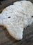 A plush off-white icelandic sheepskin rug with soft short wool and subtle gray speckles in large size 45 x 31 inches