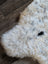 Fluffy off-white icelandic sheepskin rug with dark gray and black speckles in short wool style 45 by 31 inches