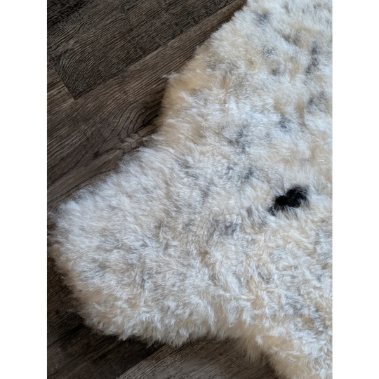Fluffy off-white icelandic sheepskin rug with dark gray and black speckles in short wool style 45 by 31 inches