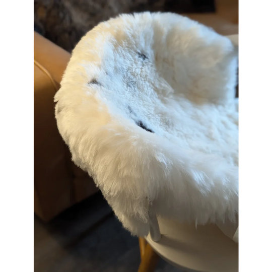 White fluffy icelandic sheepskin chair cover with soft plush texture made from medium spotted short wool sheepskins