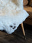 A plush off-white icelandic sheepskin rug with short wool and subtle dark paw print design spot4 41 by 29 inches