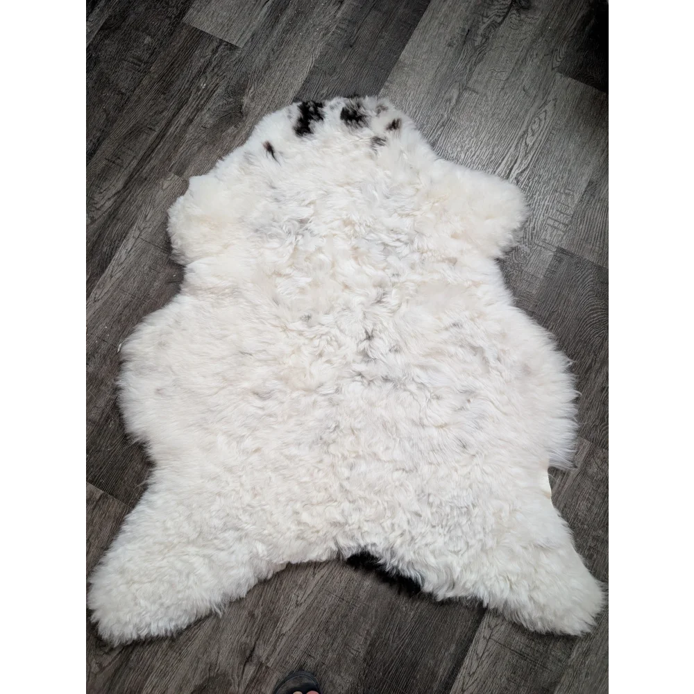 Large soft spotted icelandic sheepskin rug with white fluffy wool and natural black markings on head and shoulders