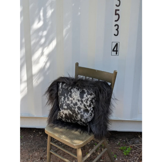 Black and white spotted cowhide pillow with long wool icelandic sheepskin trim perfect for cozy decor
