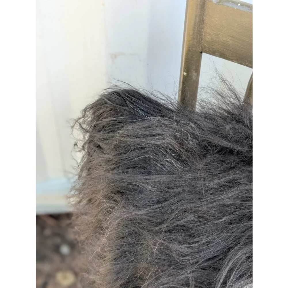 A thick shaggy gray blanket made from natural black icelandic sheepskin long wool perfect for cozy sewing machine projects