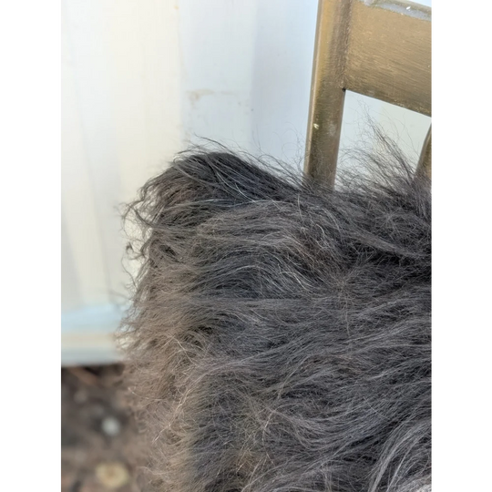 A thick shaggy gray blanket made from natural black icelandic sheepskin long wool perfect for cozy sewing machine projects