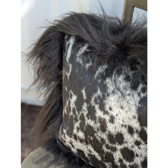Black and white spotted cowhide pillow with fluffy natural black Icelandic sheepskin long wool trim perfect for sewing machines