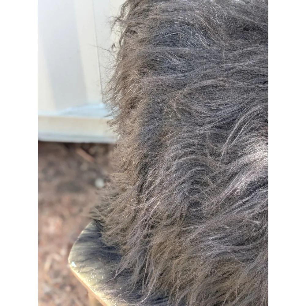 A thick shaggy spotted cowhide with natural black icelandic sheepskin and long wool texture for sewing machines