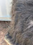 A thick shaggy spotted cowhide with natural black icelandic sheepskin and long wool texture for sewing machines