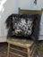 Black and white spotted cowhide pillow with long wool icelandic sheepskin trim perfect for sewing machines use