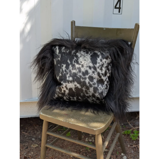 Black and white spotted cowhide pillow with long wool icelandic sheepskin trim perfect for sewing machines use
