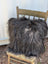 A plush spotted cowhide and natural black icelandic throw pillow with long wool icelandic sheepskin texture