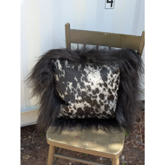 Black and white spotted cowhide pillow with fluffy natural black icelandic sheepskin long wool trim