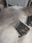 A gray fluffy sheepskin tail rests on a black cotton canvas squirrel coin purse with a cat face illustration